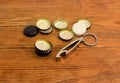 Bottle opener and different used bottle caps on rustic table