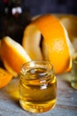 Bottle of orange essential oil with  orange slice, peel and leaf on wooden table Royalty Free Stock Photo