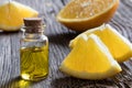 A bottle of orange essential oil with oranges on a wooden table Royalty Free Stock Photo