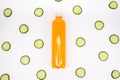 Bottle of orange smoothie on white background with cucumber pattern. Top view. Sweet drink. Detox summer drink. Healthy fresh Royalty Free Stock Photo