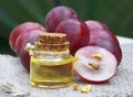 Bottle of organic grape seed oil for spa and bodycare and fresh ripe grapes berries on old wooden table.