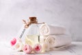 Bottle with organic  rose essential aroma oil with tag, fresh roses flowers  and white towels Royalty Free Stock Photo