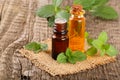 Bottle of peppermint oil and fresh mint on an old wooden background