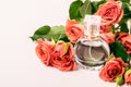 Bottle of perfume on the background of a bouquet of coral roses