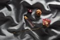 A bottle of perfume and buds of dried roses on a gray silk background. Romantic look. Top view