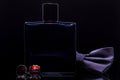 A bottle of perfume and cufflinks and a bowtie on a black Royalty Free Stock Photo