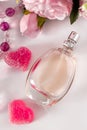 Bottle of perfume, flowers and hearts on a light background Royalty Free Stock Photo