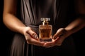 A bottle of perfume in her hand. A girl holding a bottle of perfume on her hand, sophistication Royalty Free Stock Photo