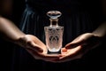 A bottle of perfume in her hand. A girl holding a bottle of perfume on her hand, sophistication Royalty Free Stock Photo