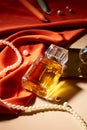 A bottle of perfume without label is displayed on a table with a string of pearls, candles and red silk. Mockup for perfume Royalty Free Stock Photo