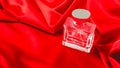 Bottle of perfume on luxury red satin fabric. background. elegant wallpaper desing Royalty Free Stock Photo