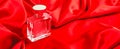 Bottle of perfume on luxury red satin fabric. background. elegant wallpaper desing Royalty Free Stock Photo