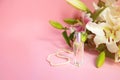 Bottle of perfume with pearl neck chain and white lilies flowers on a pink background Royalty Free Stock Photo