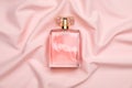 Bottle of perfume on pink silk fabric, top view Royalty Free Stock Photo