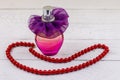 Bottle of perfume and red beads necklace on white wooden background Royalty Free Stock Photo