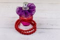 Bottle of perfume and red beads necklace on white wooden background Royalty Free Stock Photo