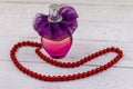 Bottle of perfume and red beads necklace on white wooden background Royalty Free Stock Photo