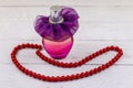 Bottle of perfume and red beads necklace on white wooden background Royalty Free Stock Photo