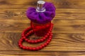 Bottle of perfume and red beads necklace on wooden background Royalty Free Stock Photo