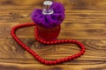 Bottle of perfume and red beads necklace on wooden background Royalty Free Stock Photo