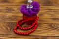 Bottle of perfume and red beads necklace on wooden background Royalty Free Stock Photo