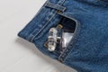 Bottle of perfume or toilet water in a pocket of blue jeans