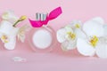 Bottle of perfume with white orchid flowers on color background. Selective focus. Royalty Free Stock Photo