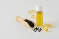 Bottle and pills of black cumin seeds essential oil. Nigella Sativa in wooden spoon on white background Royalty Free Stock Photo