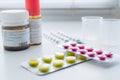 Bottle pills, measuring cup and medicine capsule on table