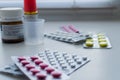 Bottle pills, measuring cup and medicine capsule on table