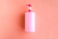 Bottle with pink dishwashing liquid on pink background. Royalty Free Stock Photo
