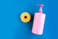 Bottle with pink dishwashing liquid and sponge on blue background Royalty Free Stock Photo