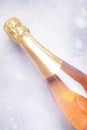 Bottle with pink sparkling wine or rose champagne and glasses, gray background with place for text, holiday or date concept, flat Royalty Free Stock Photo