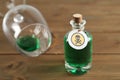 Bottle of poison and partially emptied glass on wooden table