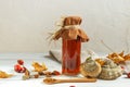 A bottle with a portion of infusion of chaga, wood mushroom with useful properties and rosehip, close-up on a light background