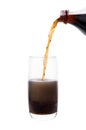 Bottle pouring coke in drink glass with ice cubes Royalty Free Stock Photo