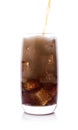 Bottle pouring Cola in drink glass with ice cubes Royalty Free Stock Photo