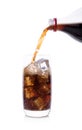 Bottle pouring Cola in drink glass with ice cubes Royalty Free Stock Photo