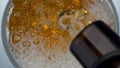 Bottle pouring craft beer in glass closeup. Lager stream making foam in drink Royalty Free Stock Photo