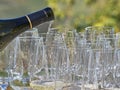 A bottle pouring wine into some glasses with the Langhe countryside in the background Royalty Free Stock Photo