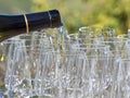 A bottle pouring wine into some glasses with the Langhe countryside in the background Royalty Free Stock Photo