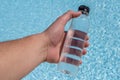 bottle with water in hand on the background of the sea