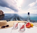 Bottle of pure water and two glasses and ripe grapefruit on deck of private yacht, cruise ship during summer vacation Royalty Free Stock Photo