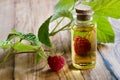 A bottle of raspberry seed oil with fresh raspberries