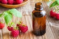 A bottle of raspberry seed oil and fresh raspberries