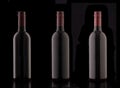 A bottle of red elite wine on a black background. Royalty Free Stock Photo
