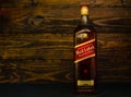 Bottle of Red Label Scotch Whisky on a dark wooden background. Johnnie Walker is one of the most legendary brands in the