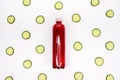 Bottle of red smoothie on white background with cucumber pattern. Top view. Sweet drink. Detox summer drink. Healthy fresh juice Royalty Free Stock Photo