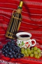 Bottle of red wine, white and red grape, and a mug of wine Royalty Free Stock Photo