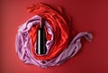 Bottle of red wine against a background of draped red and pink silk fabric Royalty Free Stock Photo